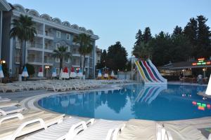 a large swimming pool with lounge chairs and a hotel at alenz suite in Marmaris