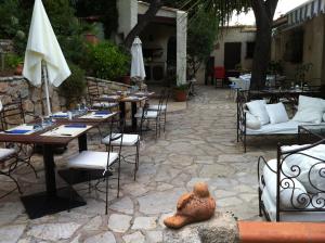 a patio with tables and chairs and a table with a statue at Villa Fabregas in La Seyne-sur-Mer
