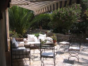 eine Terrasse mit einem Tisch, Stühlen und einem Sonnenschirm in der Unterkunft Villa Fabregas in La Seyne-sur-Mer