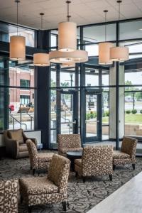 eine Lobby mit Stühlen, einem Tisch und Fenstern in der Unterkunft Kent State University Hotel and Conference Center in Kent