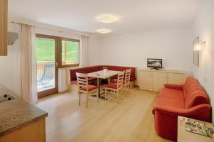 a living room with a red couch and a table at Residence Andrea in Cadipietra