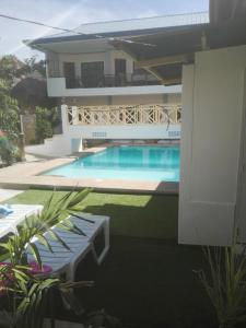 a house with a swimming pool in front of a house at Alona KatChaJo Inn in Panglao Island