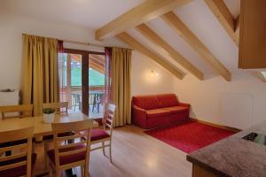 - un salon avec une table et un canapé rouge dans l'établissement Residence Andrea, à Cadipietra