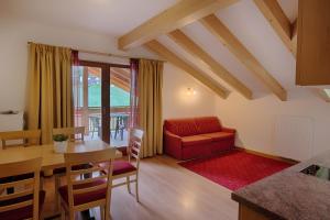 a living room with a table and a red couch at Residence Andrea in Cadipietra