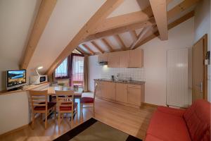 a kitchen and living room with a table and chairs at Residence Andrea in Cadipietra