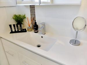 lavabo blanco en el baño con espejo en Glen Iris, Quiet Boutique 2 bedroom Netflix, WIFI, Parking, Free Wine en Melbourne