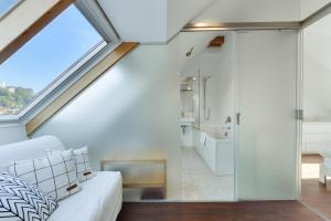 a bedroom with a large skylight and a bathroom at Fine Ljubljana Apartments in Ljubljana