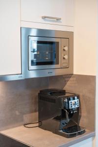 a computer on a counter in a kitchen with a microwave at RHC Central Station Premium Apartments | contactless check-in in Vienna