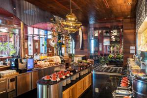 a restaurant with a bar with food on display at MeStyle Museum Hotel in Bangkok