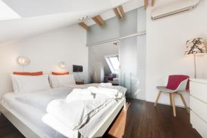 a bedroom with a large white bed and a chair at Fine Ljubljana Apartments in Ljubljana
