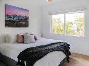 - une chambre avec un lit blanc et une grande fenêtre dans l'établissement Glen Iris, Quiet Boutique 2 bedroom Netflix, WIFI, Parking, Free Wine, à Melbourne