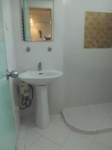 Baño blanco con lavabo y espejo en Bora Sky Hotel, en Boracay