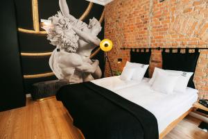 a bedroom with a bed with a statue on the wall at Apartamenty Schoeps Residence in Poznań