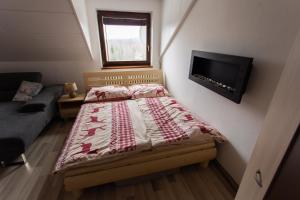 a bedroom with a bed and a flat screen tv at Apartment Vila Božena - Tatranská Lomnica in Tatranská Lomnica