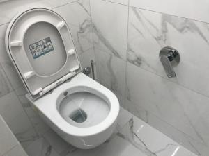 a white toilet in a bathroom with marble walls at Tra le Torri B&B - Ampia stanza privata in appartamento con bagno privato accessibile da corridoio in Bologna