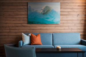 a living room with a blue couch and a polar bear swimming at Svalbard Hotell | Lodge in Longyearbyen