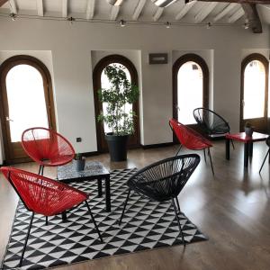 a room with red chairs and a black and white rug at Hotel Cienbalcones in Daroca