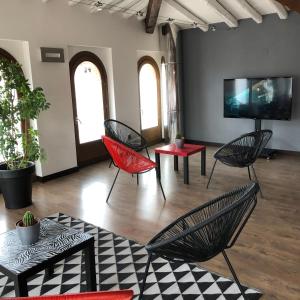 a living room with chairs and a flat screen tv at Hotel Cienbalcones in Daroca