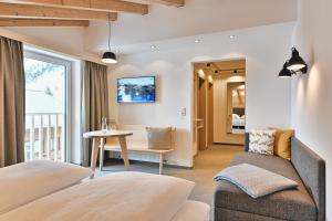 a hotel room with two beds and a table at Hotel Bianca in Lech am Arlberg