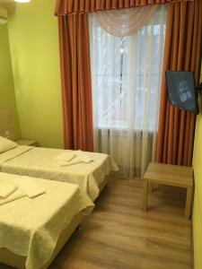 a hotel room with two beds and a window at Donskaya Riviera Hotel in Rostov on Don