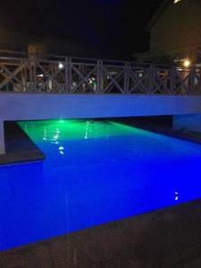 a swimming pool with blue and green illumination at night at Alona KatChaJo Inn in Panglao