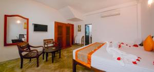 a bedroom with a bed and a table and a chair at Kamal Villa in Ahungalla