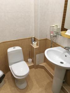 a bathroom with a white toilet and a sink at Donskaya Riviera Hotel in Rostov on Don