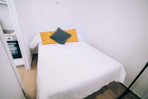 a white bed with two pillows on top of it at Old Side Platja d'Aro in Platja d'Aro