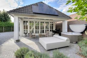 a living room with a white couch and a solar roof at Gardenhouse with private jacuzzi and sauna in Teteringen