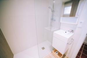 een witte badkamer met douche en wastafel bij Old Side Duplex Platja d'Aro in Platja  d'Aro
