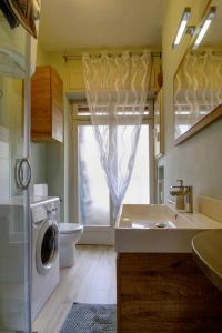a bathroom with a washing machine and a washer at La maison du boulevard in Aosta