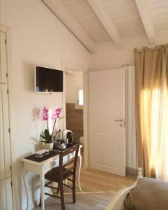 una camera da letto con scrivania e tavolo con fiori di Casa Speri a Peschiera del Garda