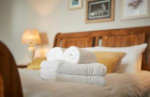 a pile of towels sitting on top of a bed at The Angel Inn Hotel in Pershore