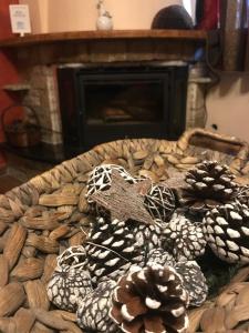 a basket full of pine cones in front of a fireplace at Tzovolos Apartments in Kalavrita