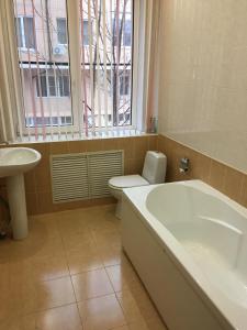 a bathroom with a tub and a toilet and a window at Donskaya Riviera Hotel in Rostov on Don