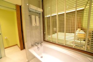 a bathroom with a bath tub and a window at Bagan Thiripyitsaya Sanctuary Resort in Bagan