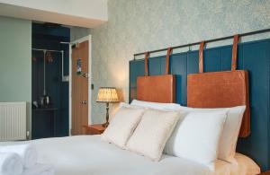 um quarto com uma cama grande e almofadas brancas em The Angel Inn Hotel em Pershore