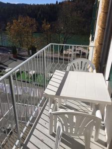 d'une table de pique-nique blanche et de deux chaises sur le balcon. dans l'établissement Hotel du Lac Parc & Residence, à Lavarone