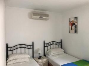 a bedroom with two beds and a air conditioner at Bungalow Isla Margarita in Puerto Rico de Gran Canaria