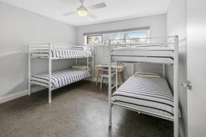 two bunk beds in a room with a window at HALE KUPA Rye Beach House Spa Table Tennis in Rye