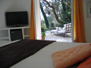 1 dormitorio con 1 cama, TV y patio en Villa Fabregas, en La Seyne-sur-Mer