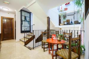 een eetkamer met een tafel en stoelen en een trap bij Casa Aljibe de Santa Ana in Granada