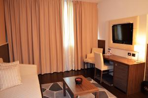 a hotel room with a desk and a television in a room at Hotel Ristorante Giada in Grumolo delle Abbadesse