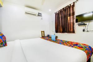 a hotel room with a bed and a television at FabHotel Grand Sheela in Patna