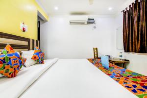 a bedroom with a bed with a laptop on it at FabHotel Grand Sheela in Patna