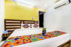 1 dormitorio con 1 cama grande y colcha colorida en FabHotel Grand Sheela, en Patna