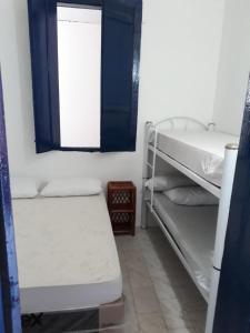 ein Zimmer mit zwei Etagenbetten und einem Fenster in der Unterkunft Casa da Praça Morro de São Paulo in Morro de São Paulo