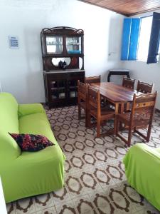 ein Wohnzimmer mit einem Tisch und einer grünen Couch in der Unterkunft Casa da Praça Morro de São Paulo in Morro de São Paulo + 15 Fotos