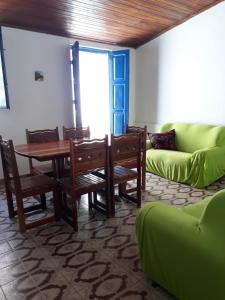 sala de estar con mesa y sofá verde en Casa da Praça Morro de São Paulo, en Morro de São Paulo