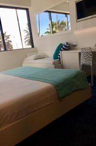 a bedroom with two beds and a desk and windows at SoBlue Hôtel in Antibes